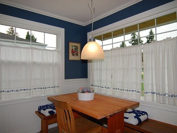 Sunny dining room features tiled floor and two large picture windows