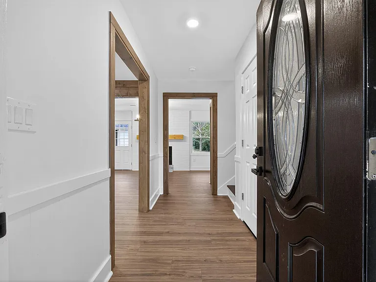 Inviting entry hall with wood-look flooring, wide doorway trim, and direct access to main living areas and a nearby closet.