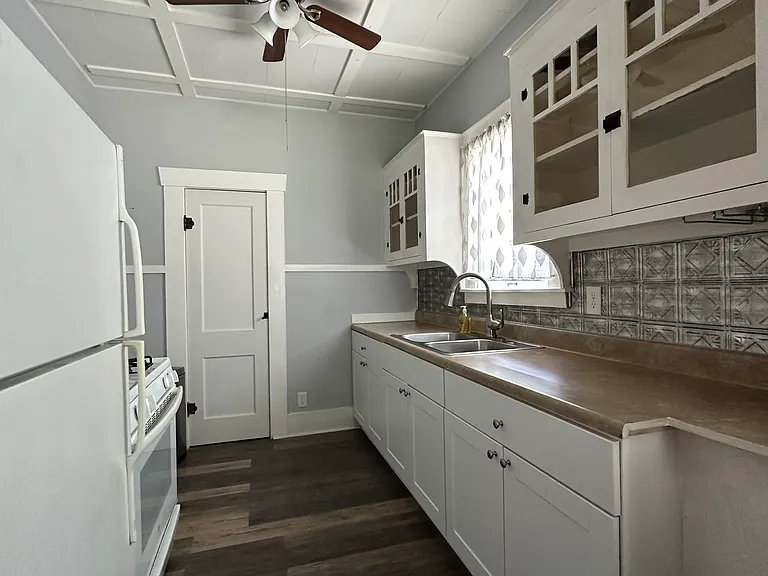 Spacious pantry with shelving at end of kitchen provides extra storage space.