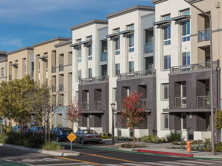 Exterior building view showcasing prime location and community access at Aster Apartments near BART.