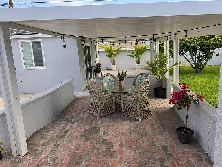 Covered Patio: Outdoor dining area with string lights that create a beautiful evening ambiance