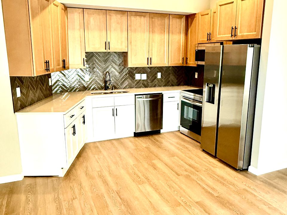 Kitchen with new butterscotch and white cabinets, stainless steel appliances, and garbage disposal