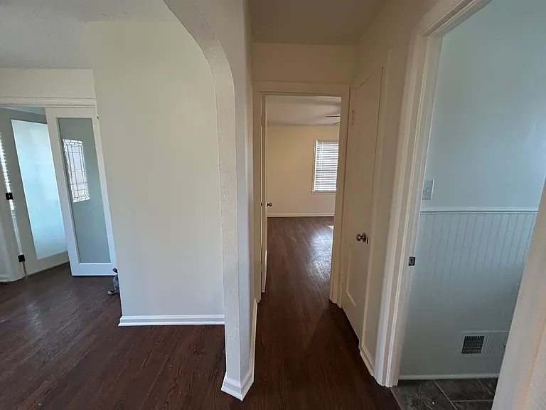 This picture shows the hallway coming from the kitchen/living room. Entryway (with general room w/ french doors) on left, main bedroom straight ahead, and main bathroom on right.
