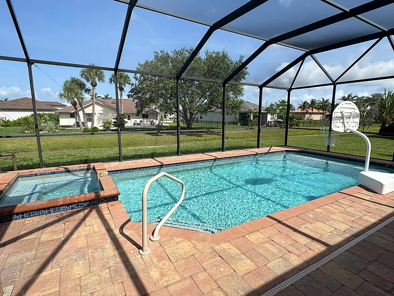 Large pool with hot tub surrounded by plenty of outdoor area