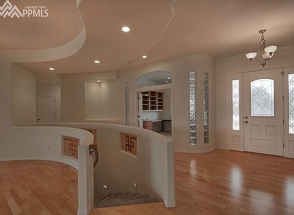 The contemporary design features curved walls and curved staircase to the basement. The office has double doors and glass brick accents.