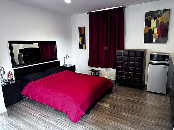 Primary Bedroom with mini fridge and microwave and balcony. 3rd floor