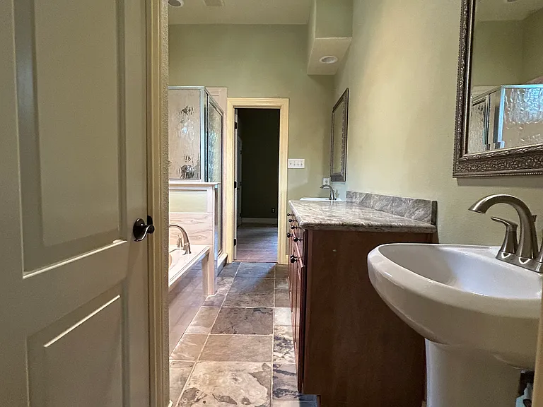 Jack and Jill bathroom connecting 2nd and 3rd bedrooms with jacuzzi tub and 2 pedestal sinks one on each side of the room
