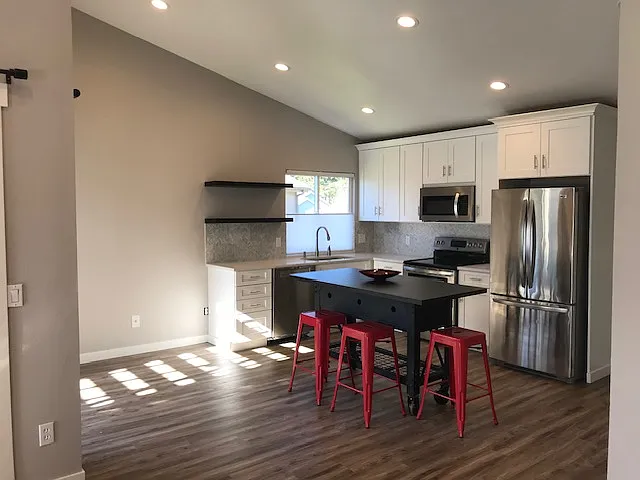Kitchen with full-size stainless steel refrigerator, oven, microwave, and dishwasher