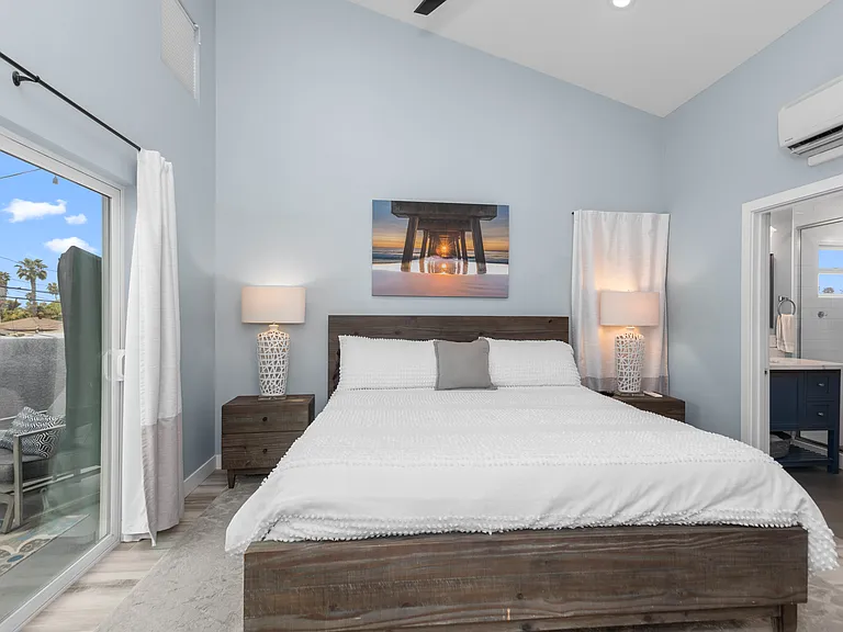 Main bedroom with plank tile floors and vaulted ceilings