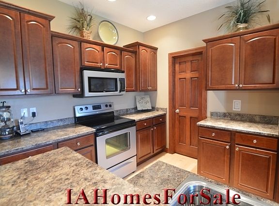 Kitchen- Cherry stained color cabinets with soft close doors and drawers and upgrade of crown molding and staggered look, oversized pantry, hardwood floors.