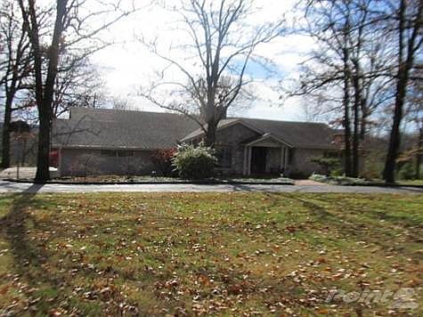 Street view with nice set back from the street, side entry garage and circular guest drive across front.