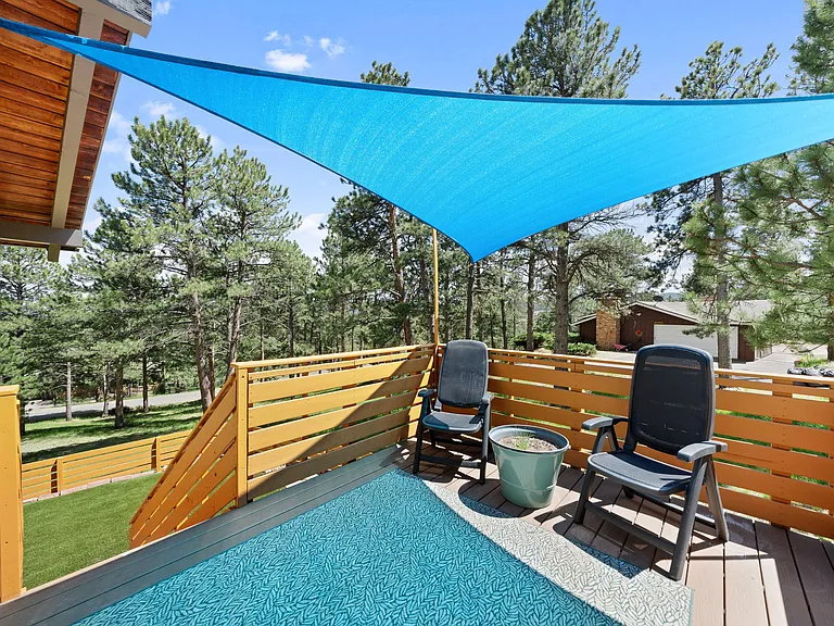 Deck seating with sunshade is a perfect spot to relax off of the living room. Outside sliding glass door 1 of 3 on main living level.