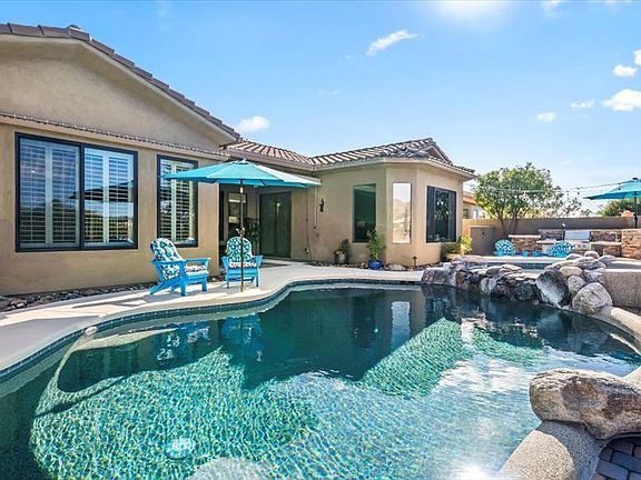 Backyard _ Feel the difference in your skin and swim in the Saltwater pebble-tec pool with two lagoons that allow umbrellas for additional shade. Soak in the 8-person spa with a beautiful waterfall feature. Pool Capable of being heated
