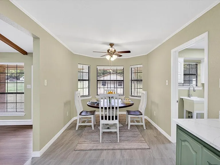 View from kitchen into the breakfast nook with a bay window overlooking fenced back yard.
