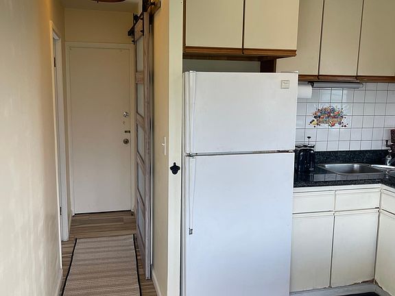 Hallway to bedroom on left, bathroom on right.