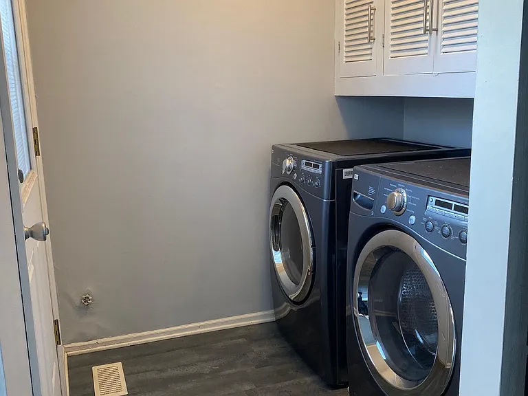 Laundry room with newer washer dryer, storage and outside access
