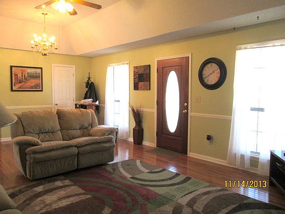 Living room with tray ceiling and hardwood floors