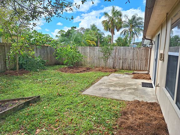 Fully fenced in backyard with patio and citrus fruit trees.