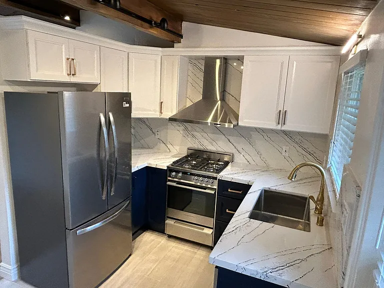 Kiitchen with french door refrigerator and gas stove. Quartz countertops.