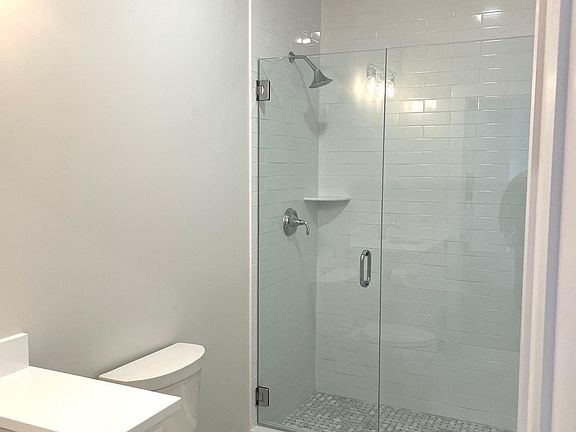 Jack and Jill bath with tiled walk in shower with frameless shower door.