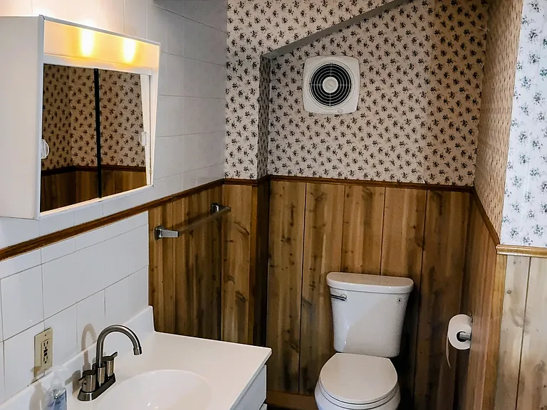 More handsome low maintenance paneling with sparkling wallpaper.
Exhaust fan works great. Brand New Super Flush Toilet! 
TP holder is submerged into the wall, 3 towel bars.