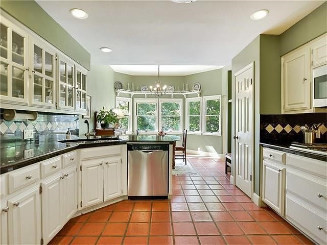 Updated kitchen with many cabinets and deep drawers for storage. Glass front cabinets. View onto bre