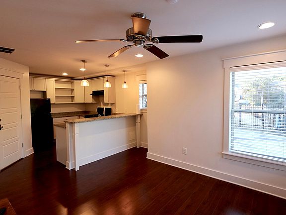 Walking into the home you enter the living area with a visual of the kitchen and bar area.