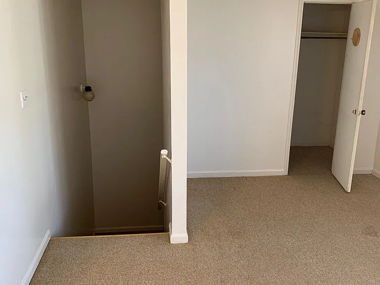 living room closet and stairs leading to door