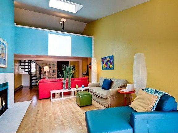 Living room with vaulted ceiling and skylight. Fireplace. Note loft in upper background.
