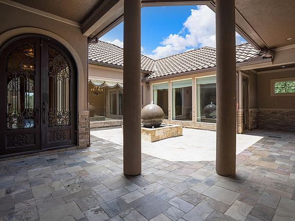 Evoke the Tuscan Villa in this courtyard with sculptured fountain and covered walk to main house entrance. Plant a couple of Bougainvilleas and enjoy your new home.