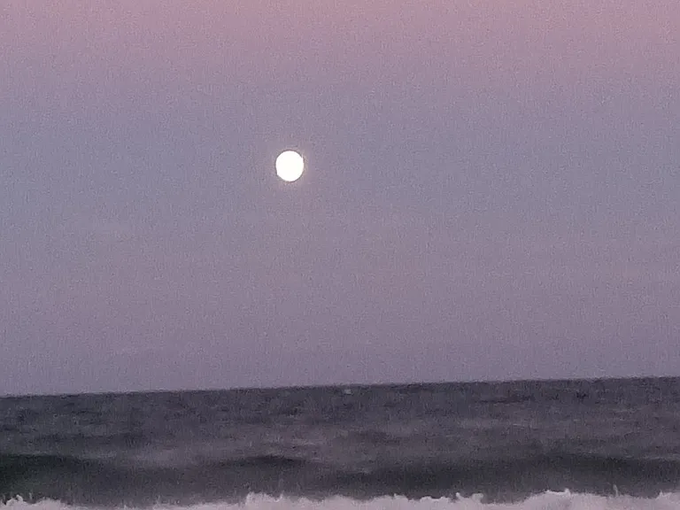 A full moon shining on the ocean as you view it from your balcony