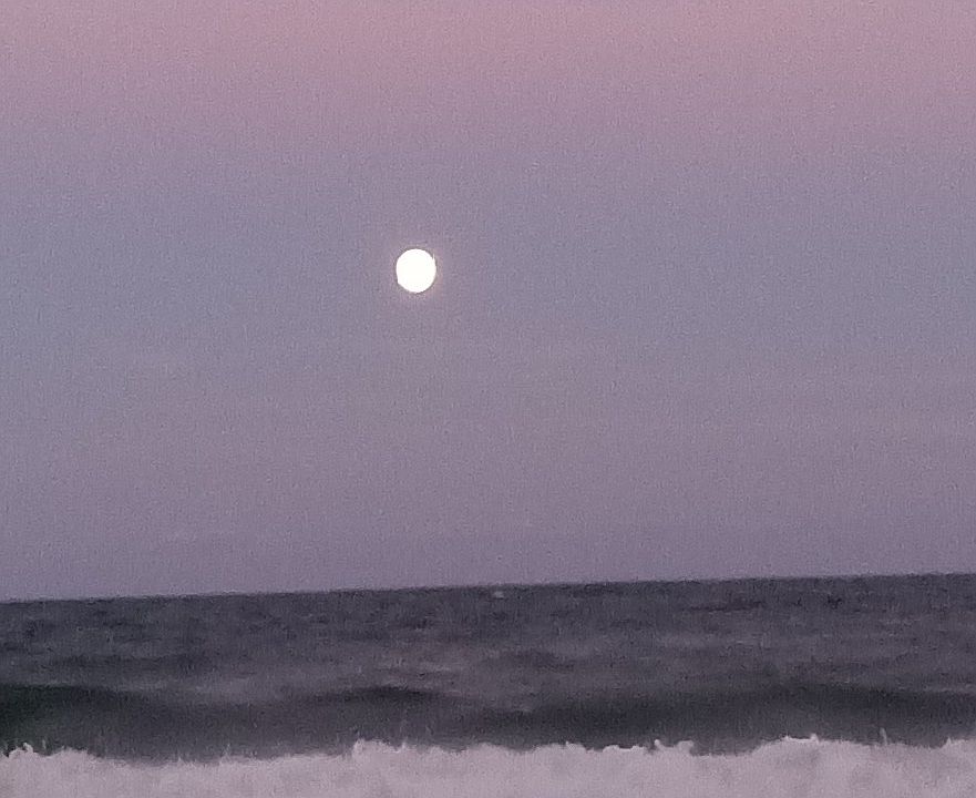 A full moon shining on the ocean as you view it from your balcony