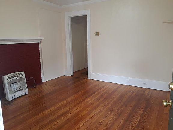 Lovely living room with original fireplace mantel and hardwood floors