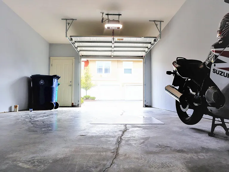 Spacious garage which fits a car, motorcycle and couple of storage closets. Additional parking space in driveway (front of garage door) for second car. New garage door opener with motion sensor and camera.