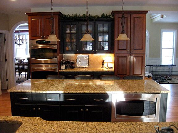 The Kitchen island and hutch feature a black distressed finish.