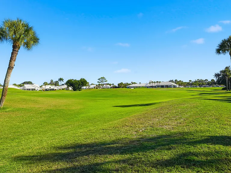 View of driving range, golf course, & clubhouse as seen from back of house