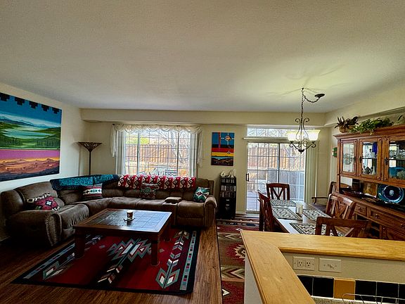 Living room/dining room with window and sliding glass door leading to enclosed back patio.
