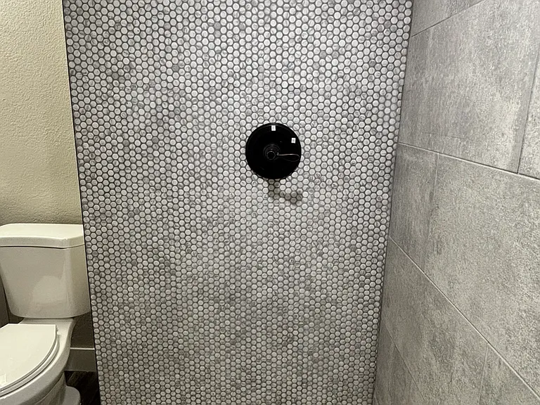 Shower space, with built in seat and sleek tile design