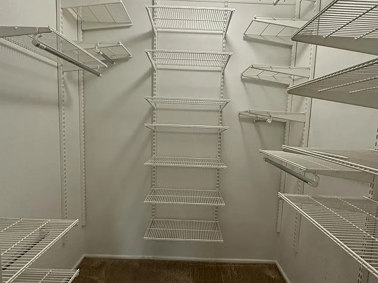 Master bedroom walk in closet with a organizers