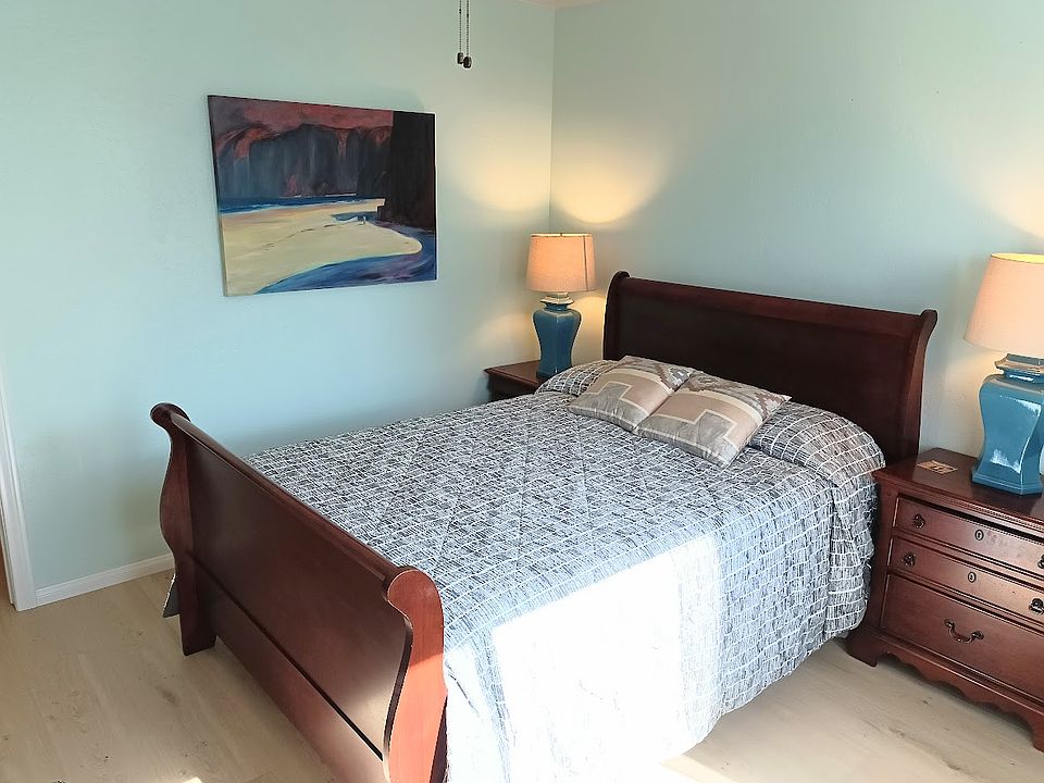 Comfy queen-size bed with two nightstand/dressers and lamps.