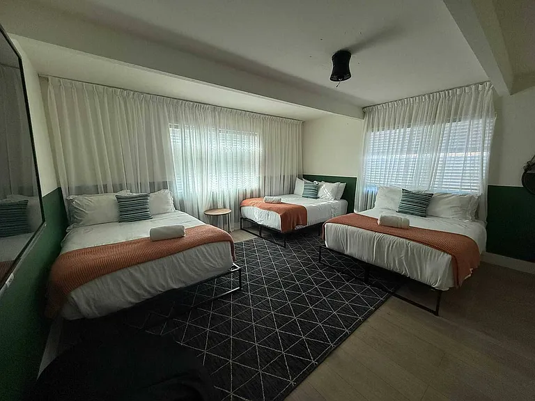 Fifth bedroom has three full sized beds and television.