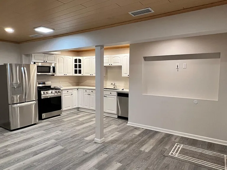 Open floorplan with kitchen and living area. Ready for your wall-mount TV.