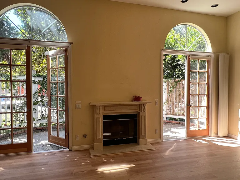 Living room with fireplace and double french door to patios