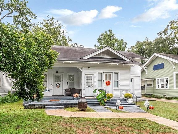 View of front of home with covered porch and a front lawn