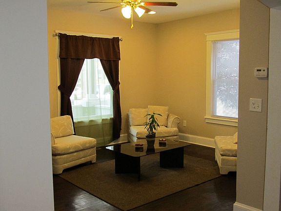 A view through one of Several Arched Doorways. Two Windows, Recessed Lights.