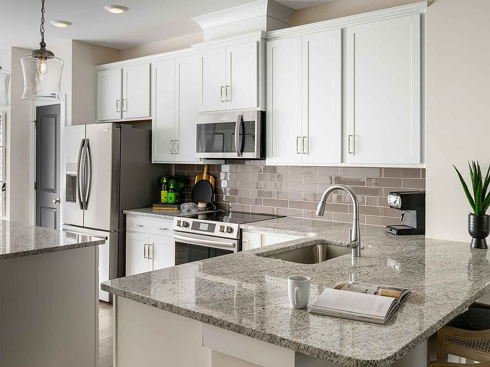 Designer kitchen with granite countertops, stainless Frigidaire appliances, under-cabinet lighting, and a large prep island with bar seating.