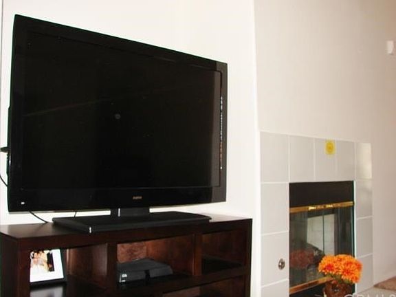 THERE'S AN ALCOVE IN THE WALL FOR YOUR ENTERTAINMENT CENTER. TILED GAS LOG FIREPLACE FOR COZY EVENINGS