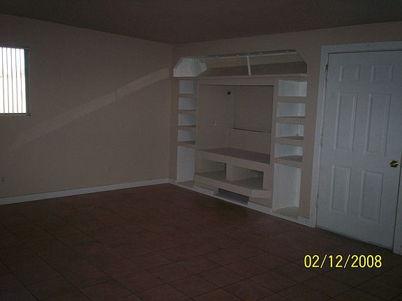 Custom media niche w/touch lighting, family room, door leads to enclosed patio