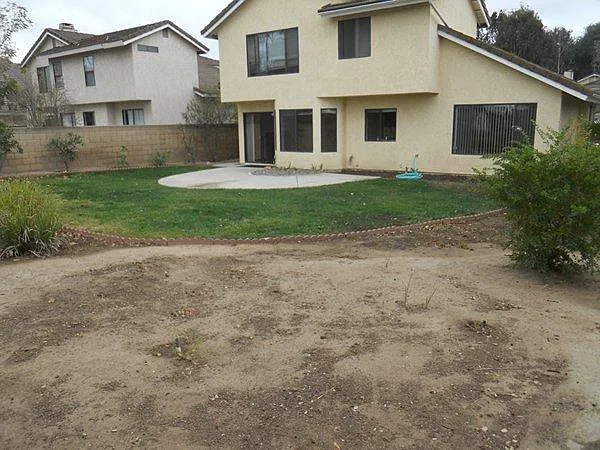 Opposite angle leading out of family room with views of house exterior and spaciousness of backyard