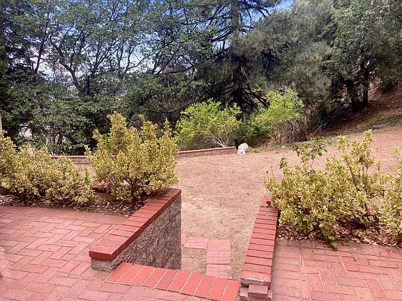 Steps to the private brick patio belonging to the studio unit with views of the back yard. Back yard abuts national forest. Very private and beautiful